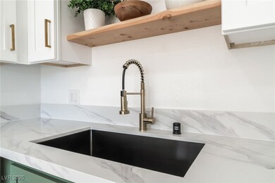 Room details with a sink, light stone countertops,