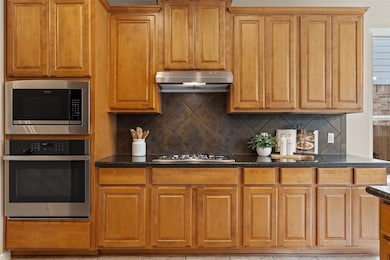 Kitchen featuring dark stone countertops, wall ch