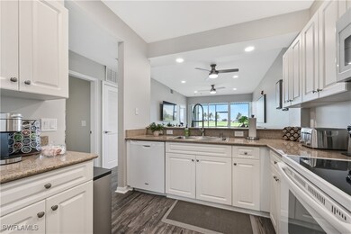 Kitchen with white cabinets, light stone countertops, white dishwasher, and recessed lighting