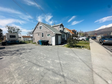 View of side of home with a mountain view and fence