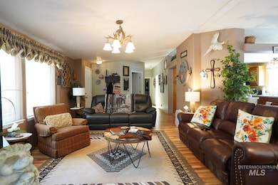 Living room with a chandelier, light wood finished floors, and plenty of natural light