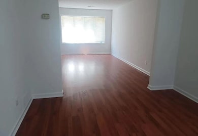Spare room with dark wood finished floors and baseboards