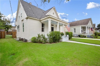 View of front of house featuring a porch, a shingled roof, and a gate