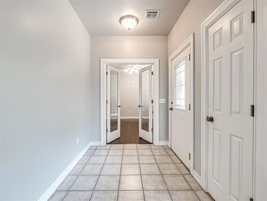 Tiled foyer with french doors and ceiling fan