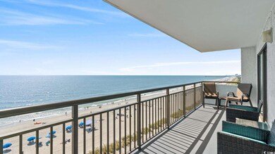 Balcony featuring view of water and beach