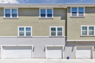 Rear view of property with an attached garage, stucco siding, and driveway
