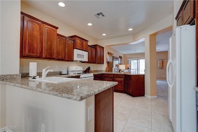 Kitchen featuring visible vents, a peninsula, whit
