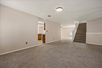 Spare room featuring a textured ceiling, stairway