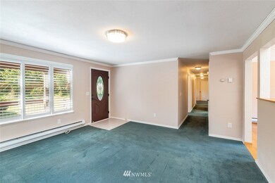 Living room by the front door and open to the kitchen. Woodstove too.