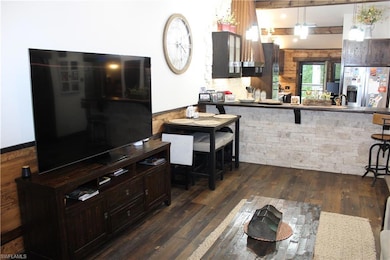 Kitchen featuring dark brown cabinets, dark wood-s