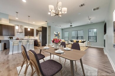 Dining space with a chandelier, a ceiling fan, rail lighting, and light wood-type flooring