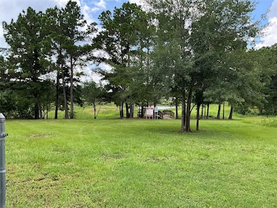 View of grassy yard featuring view of wooded area