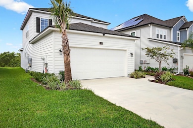View of home's exterior with an attached garage, concrete driveway, a shingled roof, and a yard