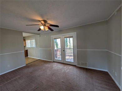 Carpeted spare room with visible vents, a textured