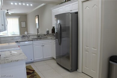 Kitchen with stainless steel fridge, white cabinet