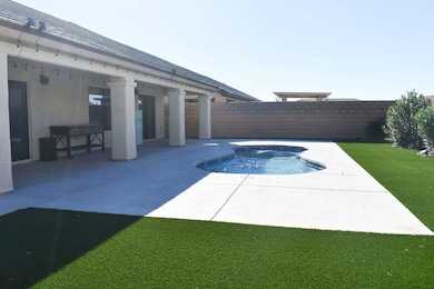 View of pool featuring a covered patio, a fenced backyard and completely landscaped