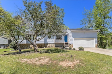 View of front of house with a front yard, an attac