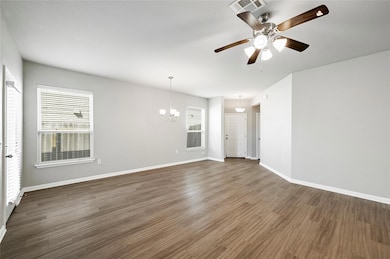 Spare room with dark wood finished floors, a chan