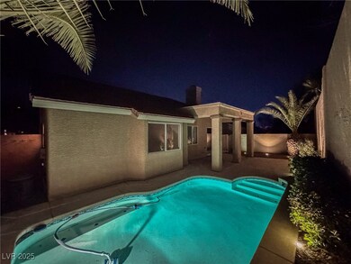 Pool at night featuring a patio