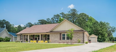 Ranch-style home featuring a front yard, brick sid