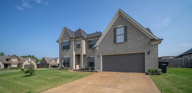 View of front of house with an attached garage and driveway