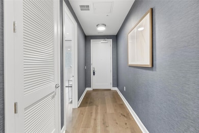 Doorway featuring wood finished floors and baseboards
