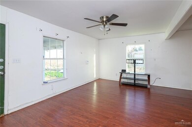 Unfurnished room featuring ceiling fan, wood finished floors, and a wealth of natural light