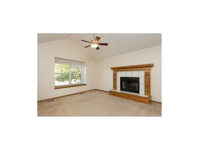 Living room with vaulted ceiling and fireplace