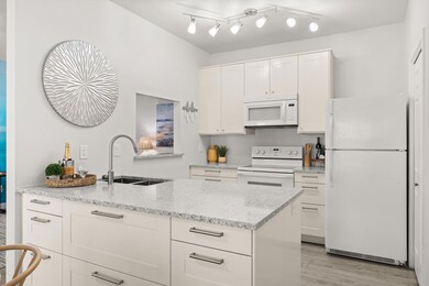 Kitchen featuring white appliances, a sink, white