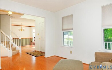 Entryway featuring wood finished floors, a chandelier, stairs, and crown molding
