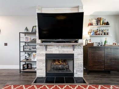 Fireplace surrounded by upgraded stone feature wit