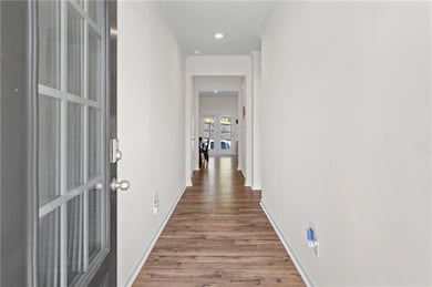 Hall featuring wood finished floors, baseboards, f