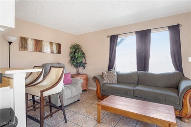 Living room with a textured ceiling and light tile