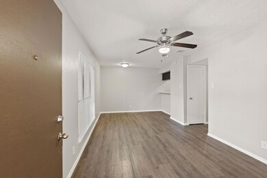 Empty room featuring dark wood finished floors, ceiling fan, and a textured ceiling