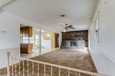 The living room features a rock fireplace and opens to the back patio.