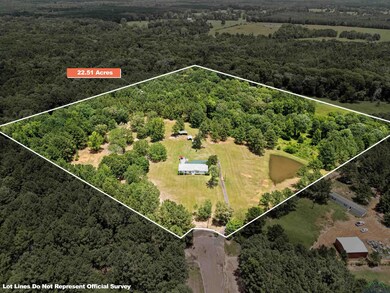 Aerial view of property and surrounding area with a heavily wooded area and property parcel outlined