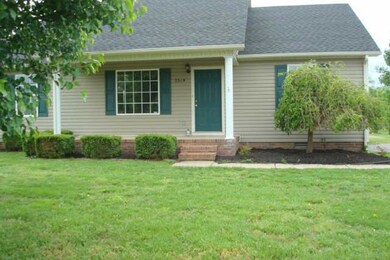 Driveway side of home with doorway to side entrance