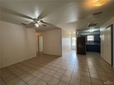 Empty room with light tile patterned floors, ceiling fan, and a sink