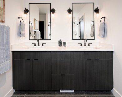 Bathroom featuring double vanity and dark tile patterned floors