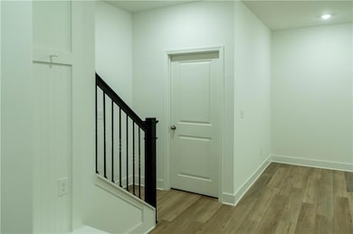 Stairway with wood finished floors and baseboards