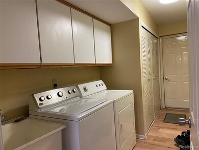 Laundry area featuring cabinet space, light wood finished floors, and separate washer and dryer