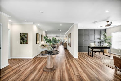 Hallway featuring crown molding, recessed lighting, light wood finished floors, and a desk