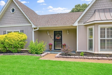 View of front of home with roof with shingles, a front lawn, and stucco siding