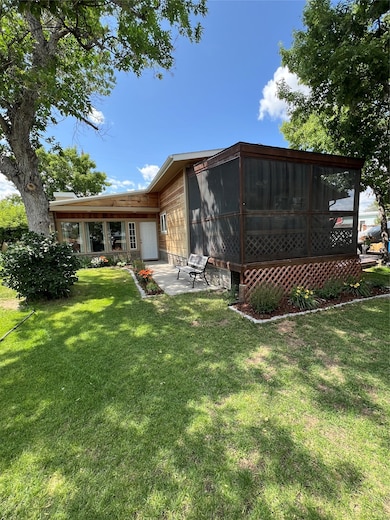 Back of property with a sunroom, a yard, a patio area, and a wooden deck