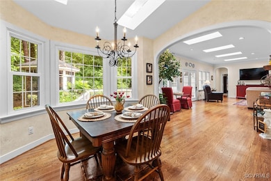 Dining space with arched walkways, a skylight, ple