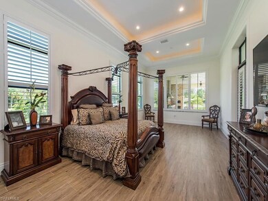 Bedroom featuring a tray ceiling, light hardwood /