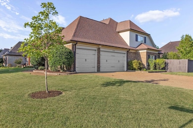 Traditional home featuring brick siding, a shingled roof, dirt driveway, and an attached garage