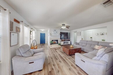 Living room featuring a tile fireplace, ceiling fa