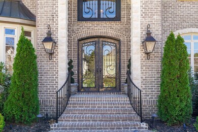 Oversized gas lanterns and french iron doors show the level of finishes offered throughout the home.