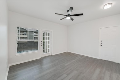 Spare room with wood finished floors, ceiling fan